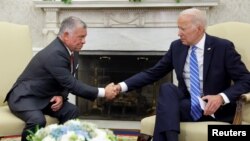 Presiden AS Joe Biden berjabat tangan dengan Raja Abdullah dari Yordania di Ruang Oval Gedung Putih di Washington, 19 Juli 2021. (Foto: Reuters)