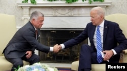 FILE - U.S. President Joe Biden shakes hands with Jordan's King Abdullah in the Oval Office at the White House in Washington, July 19, 2021. The king with meet with Biden in Washington on May 13, 2022.