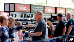Convention attendees wait in line to buy NRA branded merchandise at the NRA Store, located in the hallway adjacent to the exhibit hall at the NRA Annual Meeting held on May 26, 2022, in Houston.