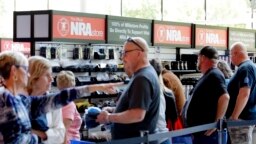 Los asistentes a la convención hacen fila para comprar productos de la marca NRA en la Tienda NRA, ubicada en el pasillo adyacente a la sala de exposiciones en la Reunión Anual de la NRA celebrada el 26 de mayo de 2022 en Houston.