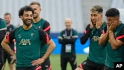 Liverpool's Mohamed Salah, left, smiles as Liverpool's Alex Oxlade-Chamberlain, right, and Liverpool's Roberto Firmino look on.