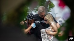 People observe a moment of silence for the victims of the Buffalo supermarket shooting outside the Tops Friendly Market, May 21, 2022, in Buffalo, N.Y.