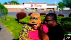 People embrace at the scene of Saturday's shooting at a supermarket, in Buffalo, NY, May 19, 2022.