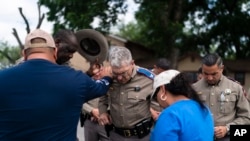 Texas Department of Public Safety Director Steven McCraw, center, prays with pastor Gabriel Davila and wife, Sylvia, outside Robb Elementary School in Uvalde, Texas, May 30, 2022.