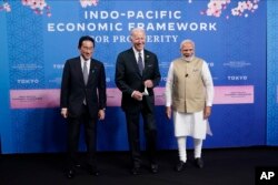 FILE - Japanese Prime Minister Fumio Kishida, left, President Joe Biden and Indian Prime Minister Narendra Modi pose for photos as they arrive at the Indo-Pacific Economic Framework for Prosperity launch event at the Izumi Garden Gallery, May 23, 2022, in Tokyo.
