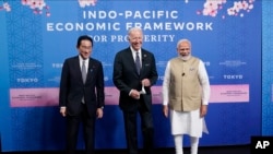 Japanese Prime Minister Fumio Kishida, left, U.S. President Joe Biden and Indian Prime Minister Narendra Modi pose for photos as they arrive at the Indo-Pacific Economic Framework for Prosperity launch event at the Izumi Garden Gallery, May 23, 2022, in Tokyo.