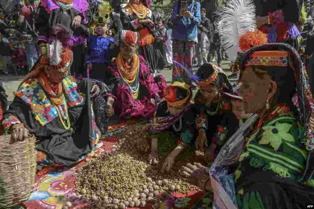 Kalash tribe women wearing traditional dresses arrive to take part in the &#39;Chilam Joshi&#39; festival celebrating the arrival of spring at Bumburet village, Pakistan.