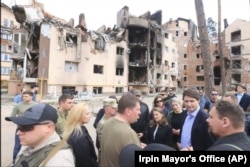 Canadian Prime Minister Justin Trudeau, second from right, speaks with Irpin Mayor Oleksandr Markushyn, center wearing t-shirt, in Irpin, Ukraine, May 8, 2022.