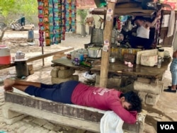 At this pavement stall, a worker rests as temperatures in May crossed 45 degrees celsius. (Anjana Pasricha/VOA)