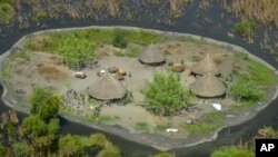 FILE - Thatched huts surrounded by floodwaters are seen from the air in Old Fangak county in Jonglei state, South Sudan on Nov. 27, 2020. 