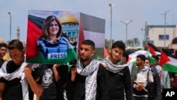 Para siswa membawa peti mati tiruan saat mereka mengadakan pemakaman simbolis untuk jurnalis Al Jazeera yang terbunuh, Shireen Abu Akleh, di Universitas al-Azhar di Mughraqa, Jalur Gaza tengah, 16 Mei 2022.
