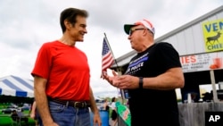 FILE - Mehmet Oz meets with an attendee during a visits to a car show in Carlisle, Pennsylvania, May 14, 2022.