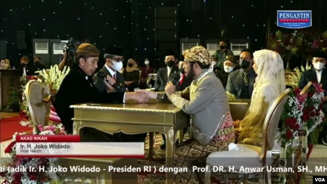 Presiden Jokowi saat menikahkan adik kandungnya, Idayati dengan ketua MK, Anwar Usman di Solo, Kamis (26/5). (Tangkapan Layar/VOA)