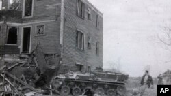 In this still frame from circa 1961 WJAR-TV newsreel footage provided by the Rhode Island Historical Society, an armored military vehicle is used to demolish a residential building in what was then known as the Lippitt Hill neighborhood, in Providence, RI.
