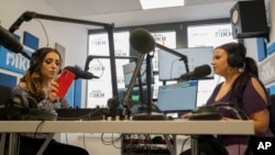 Melanie Nagy, left, and Szandi Minzari, right, hosts of Radio Dikh's women's show 'Zsa Shej' work together in a radio studio in Budapest, Hungary, May 6, 2022. 
