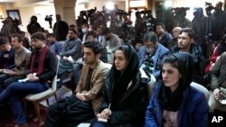 FILE - Afghan journalists attend a press conference of a former President Hamid Karzai in Kabul, Afghanistan, Feb. 13, 2022.