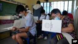 Voters cast their ballots on Monday, May 9, 2022, in Quezon City, Philippines. Filipinos began voting for a new president on Monday with the son of an ousted dictator and a champion of reforms and human rights as top contenders in a tenuous moment in a de
