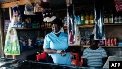 FILE: Virginia Mutsamwira, 52, a senior nurse, looks on at a small grocery shop she runs at her home to supplement her nursing income for her extended family of eight in Harare, to make ends meet. Taken April 25, 2022.