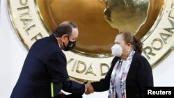 María Consuelo Porras le da la mano al presidente Alejandro Giammattei, luego de jurar como fiscal general hasta 2026, en el Palacio Nacional, en la Ciudad de Guatemala, Guatemala, el 16 de mayo de 2022.