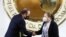 María Consuelo Porras le da la mano al presidente Alejandro Giammattei, luego de jurar como fiscal general hasta 2026, en el Palacio Nacional, en la Ciudad de Guatemala, Guatemala, el 16 de mayo de 2022.