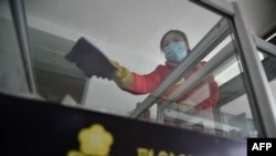 An employee cleans a surface as part of preventative measures against the COVID-19 coronavirus at the Pyongyang Children's Department Store in Pyongyang on March 18, 2022.