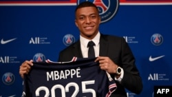 Kylian Mbappe du Paris Saint-Germain pose avec un maillot à l'issue d'une conférence de presse au stade du Parc des Princes, Paris le 23 mai 2022.