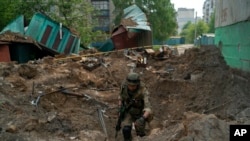 Un policía de la fuerza especial inspecciona un sitio después de un ataque aéreo de las fuerzas rusas en Lysychansk, región de Lugansk, Ucrania, el 13 de mayo de 2022.