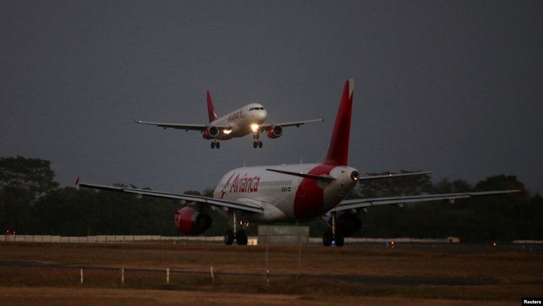 Un avión de Avianca Airlines aterriza mientras otro se prepara para despegar en el Aeropuerto Internacional San Oscar Arnulfo Romero en San Luis Talpa, El Salvador, el 8 de febrero de 2022. 
