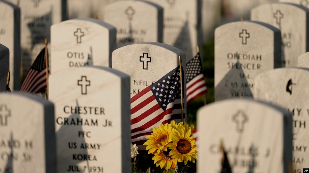 Batu nisan dihiasi dengan bendera Amerika di Leavenworth National Cemetery pada malam Memorial Day, Minggu, 29 Mei 2022, di Leavenworth, AS. (Foto: AP/Charlie Riedel)