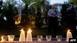 Police look on as candles left by pro-choice demonstrators sit outside the house of Supreme Court Justice Samuel Alito in Alexandria, Virginia, on May 9, 2022.