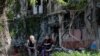دو شهروند اوکراینی ساکن شهر ماریوپول در مجموعه‌ای از ساختمان‌های مسکونی ویران‌شده در نتیجه تهاجم روسیه به اوکراین. ٢٠ مه ٢٠٢٢