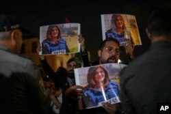 Para pengunjuk rasa memegang foto jurnalis Al Jazeera yang terbunuh Shireen Abu Akleh di perbatasan Israel di Haifa, Israel, 11 Mei 2022. (Foto: AP)