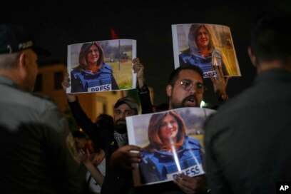 Para pengunjuk rasa memegang foto jurnalis Al Jazeera yang terbunuh Shireen Abu Akleh di perbatasan Israel di Haifa, Israel, 11 Mei 2022. (Foto: AP)