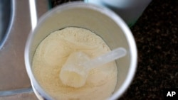 Only a few scoops are left in her next-to-last can, as Yury Navas, 29, makes formula for her infant son, Jose Ismael Gálvez, 2 months, in Laurel, Md., May 23, 2022.