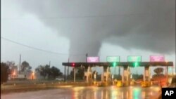 FILE - In this image taken from video provided by Scott Smith, a fast-moving tornado is seen in the distance through a windshield just before the toll booth for the Burlington Bristol Bridge, Sept. 1, 2021, in Burlington, N.J.