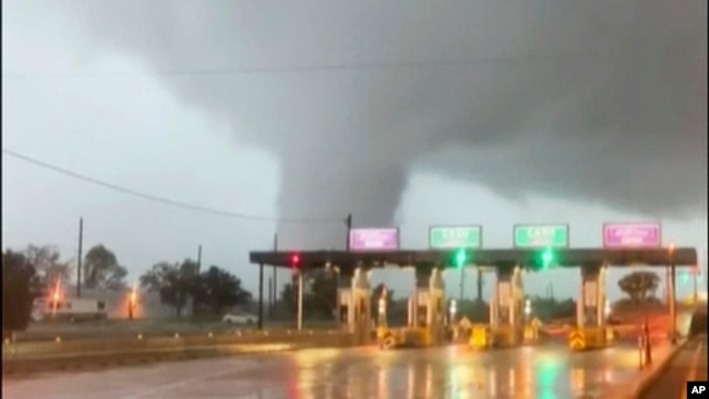 FILE - In this image taken from video provided by Scott Smith, a fast-moving tornado is seen in the distance through a windshield just before the toll booth for the Burlington Bristol Bridge, Sept. 1, 2021, in Burlington, N.J.