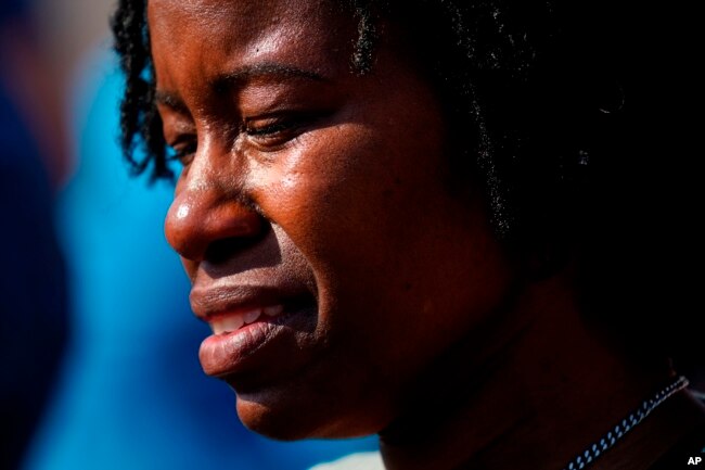 A person is overcome with emotions outside the scene of a shooting at a supermarket, in Buffalo, N.Y., May 15, 2022.