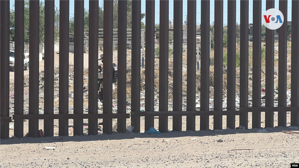 Un miembro de la Guardia Nacional Mexicana está vigilando esta zona en la frontera entre México y Estados Unidos, en el área de Sundland. El militar armado hace parte de un grupo a lo largo de la frontera mexicana, encargado de la tarea de evitar que las personas crucen de manera irregular. [Foto: Celia Mendoza, mayo 18, 2022, El Paso, Texas]