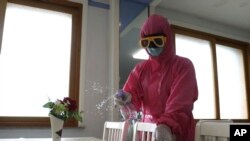 FILE - An employee of Pyongyang Dental Hygiene Products Factory disinfects the floor of a dinning room as the state increased measures to stop the spread of illness in Pyongyang, North Korea, May 16, 2022. 