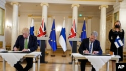 El primer ministro británico, Boris Johnson, a la izquierda, y el presidente de Finlandia, Sauli Niinisto, firman una garantía de seguridad en el Palacio Presidencial de Helsinki, Finlandia, el 11 de mayo de 2022.