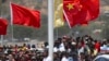 FILE - Spectators hold a Chinese flag as they watch a ceremony to mark the opening of Independence Drive Boulevard in Port Moresby, Papua New Guinea, Friday, Nov. 16, 2018. (AP Photo/Mark Schiefelbein, Pool, File)
