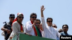 Ousted Pakistani Prime Minister Imran Khan gestures as he travels on a vehicle to lead a protest march to Islamabad, in Mardan, Pakistan, May 25, 2022.