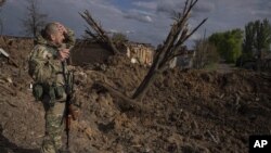 Un militar ucraniano inspecciona un lugar tras un ataque aéreo de fuerzas rusas en Bahmut, Ucrania, el martes 10 de mayo de 2022. (AP Foto/Evgeniy Maloletka)