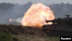 FILE - A Polish Leopard 2PL tank fires during a Defender Europe 2022 military exercise of NATO troops near Orzysz, Poland, May 24, 2022. 