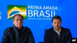 Brazil's President Jair Bolsonaro, left, and his communications minister, Fabio Faria, give a press conference after meeting with Elon Musk in Porto Feliz, Brazil, May 20, 2022.