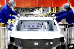 FILE - In this photo released by China's Xinhua News Agency, laborers work at the assembly workshop of automaker SAIC Motor Company's Lingang base in Shanghai, April 23, 2022. (Chen Jianli/Xinhua via AP, File)