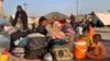 FILE - Afghan families sit outside their tents in an open area on the outskirts of Chaman, a border town in the Pakistan's southwestern Baluchistan province, Aug. 31, 2021. 