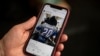 ARCHIVO - Un periodista de AFP sostiene un teléfono inteligente que muestra la cuenta de Instagram de la estrella de la música country Garth Brooks.