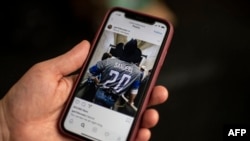 ARCHIVO - Un periodista de AFP sostiene un teléfono inteligente que muestra la cuenta de Instagram de la estrella de la música country Garth Brooks.