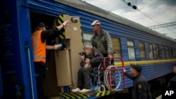 People fleeing from shelling board an evacuation train at the train station, in Pokrovsk, eastern Ukraine, Sunday, May 22, 2022. Civilians fleeing areas near the eastern front in the war in Ukraine Sunday described scenes of devastation as their towns an